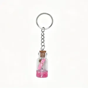 Mini glass wish bottle keychain with pink liquid and rolled note, perfect cute bag charm.