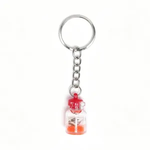 Creative luminous drift bottle keychain with orange sand and tiny shell pendant accessory.