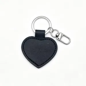 Black heart shaped PU leather keychain detail with metal ring and clasp, smooth gift pendant.