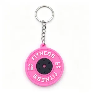 Close-up detail of the pink barbell plate keychain, showing the textured fitness design clearly.