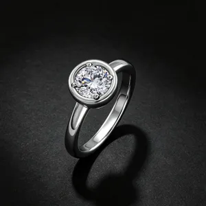 Gros plan du solitaire rond minimaliste avec éclat de diamant étincelant et anneau élégant.