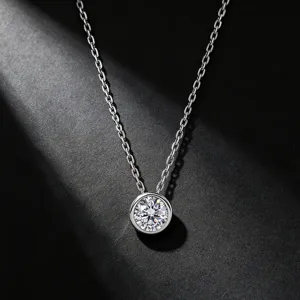 Gros plan détaillé d'un collier pendentif solitaire en argent avec serti clos et chaîne.