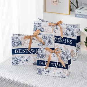 Luxus blaue Papiertüte mit Blumenmuster und goldenen Schleifen für Geschenk und Kosmetik
