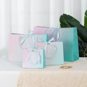 Gradient gift paper bags with ribbons, elegant packaging bags for clothing stores and holidays.