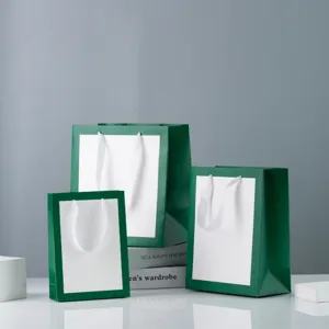 Close-up detail of multi-size green and white paper gift bags displayed cleanly in studio.