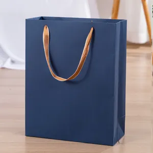 Dunkelblaue Papiertragetasche mit luxuriösen Goldband-Griffen, edle Geschenkverpackung.