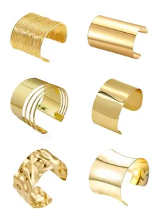 Detailed view of assorted gold metal open cuff bracelets featuring various fashionable textures and styles.