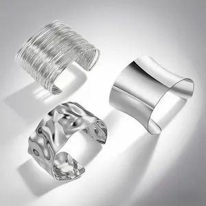 Close-up view of three stylish metallic open cuff bracelets with unique textures.