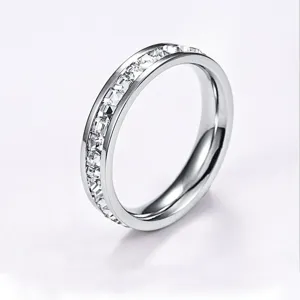 Close-up of a sleek silver-tone channel-set crystal ring, sparkling zircon detail.