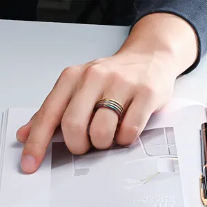 Nahaufnahme Detail mehrschichtiger stapelbarer Titanstahl schmale Ringe an der Hand.