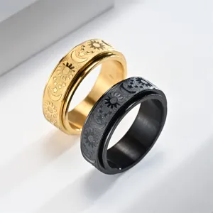 Close-up detail view of stainless steel spinner ring featuring sun, moon and star relief.
