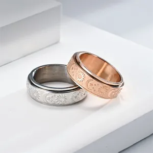 Close-up detail of stainless steel spinner rings with sun, moon, and star relief patterns.