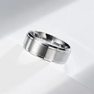 Dettaglio anello da uomo in acciaio inossidabile con texture spazzolata e scanalature.