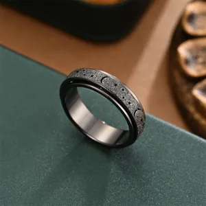 Closeup detail of stainless steel rotating ring featuring frosted star and moon pattern.