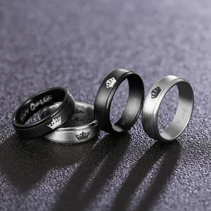 Close-up detail of 6mm couple rings with laser engraved crown patterns and lettering.