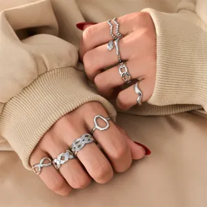 Gros plan détaillé de bagues minimalistes argentées tendance portées sur mains, bijoux.