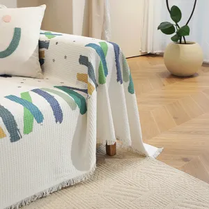 Détail du jeté de canapé en nid d'abeille avec motifs colorés et franges