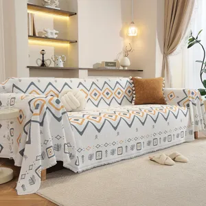 Housse de canapé géométrique style nordique avec franges dans un salon chaleureux et cosy