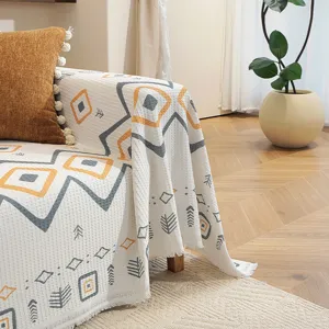 Gros plan sur les motifs géométriques et les franges d'un jeté de canapé gaufré