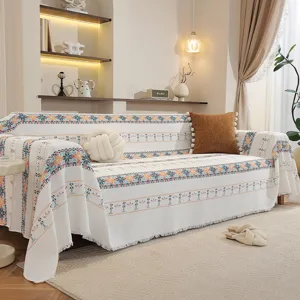 Détail d'un jeté de canapé gaufré bohème avec des motifs ethniques colorés et des franges
