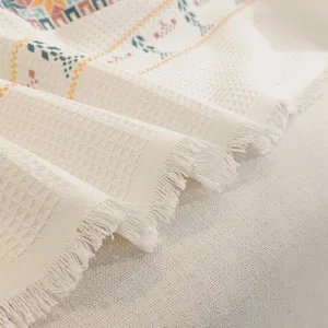 Gros plan d'une couverture de canapé de style nordique en nid d'abeille avec franges