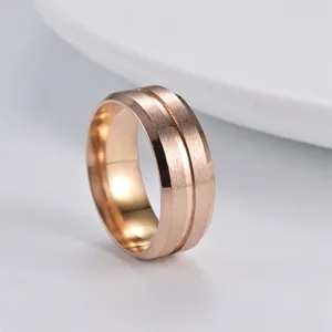 Close-up detail of mens rose gold stainless steel ring with brushed finish and groove.