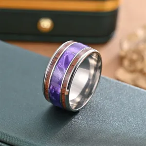 Stainless steel wide ring detail showing purple resin and wood grain inlay texture close-up shot.