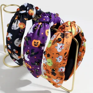 Halloween themed knotted headband detail, featuring pumpkin and ghost prints with rhinestones.