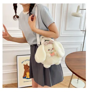 Detail of cute white plush bunny doll shoulder bag with a pink bow worn by model