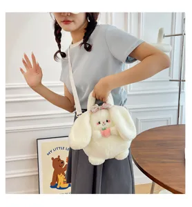 Detail view of cute white plush bunny crossbody bag with long ears worn by a model