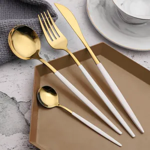 Stainless steel flatware set with luxury gold heads and elegant white handles for dining.