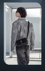 Detail shot of black nylon crossbody shoulder bag worn by model in modern architectural setting.