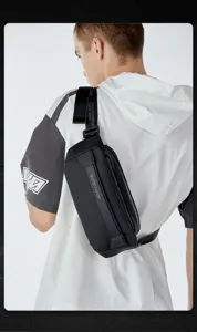 Detail shot showing the durable black chest bag worn by a model, highlighting strap and branding.