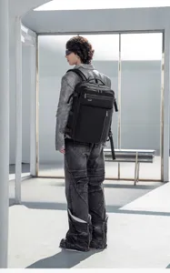 Detailed view of the stylish men's travel backpack worn by a model in an urban setting.