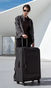 Detailansicht eines schwarzen Reisekoffers mit Rollen und Griff in einer modernen urbanen Szene.