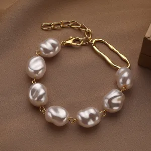 Primer plano de una elegante pulsera de perlas barrocas con cierres y detalles dorados
