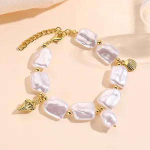 Vista detallada de pulsera de perlas barrocas con perlas irregulares y dijes dorados
