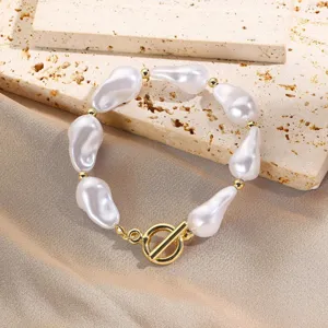 Detalle de pulsera de perlas barrocas con elegante cierre de palanca en T dorado