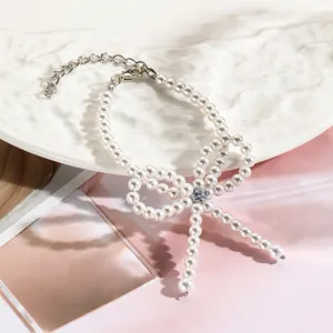 Primer plano de una elegante pulsera de perlas en forma de lazo con un cristal central