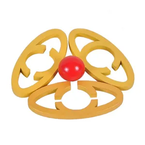 Wooden puzzle detail shot showing interlocking golden rings and a red central ball.