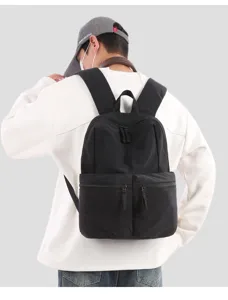 Vista dettagliata dello zaino nero in tessuto indossato dal modello con doppie tasche.