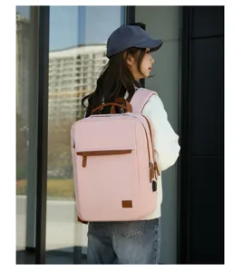 Casual pink laptop backpack detail shot with brown leather trim, multiple compartments.