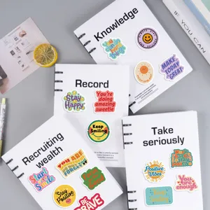 Detail view of colorful positive affirmation stickers arranged on notebooks for DIY decor.
