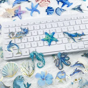 Detailed close-up of blue gold-stamped ocean theme transparent PET stickers for journal decoration.