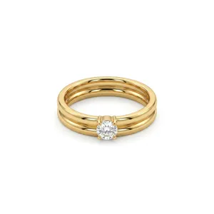 Close-up detail of a double-band gold ring featuring a sparkling solitaire diamond prong set.