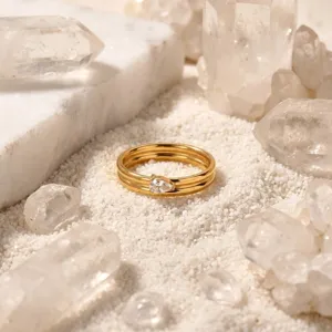 Minimalist double layer gold ring with a pear cut diamond accent for chic commute wear.