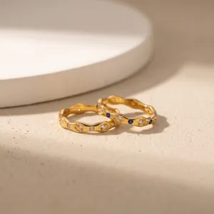 Gedetailleerde close-up van titanium stalen golfring met witte diamanten en blauwe saffieren.