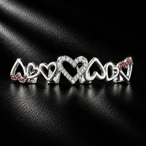 Detailed view of luxury hip hop heart grillz with cubic zirconia and red gems.