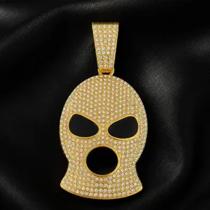 Close-up of gold-plated hip-hop ski mask pendant with rhinestones and black enamel eyes.