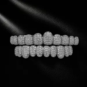 Close-up detail of iced out hip hop grillz featuring micro pave zircon stones on metal base.